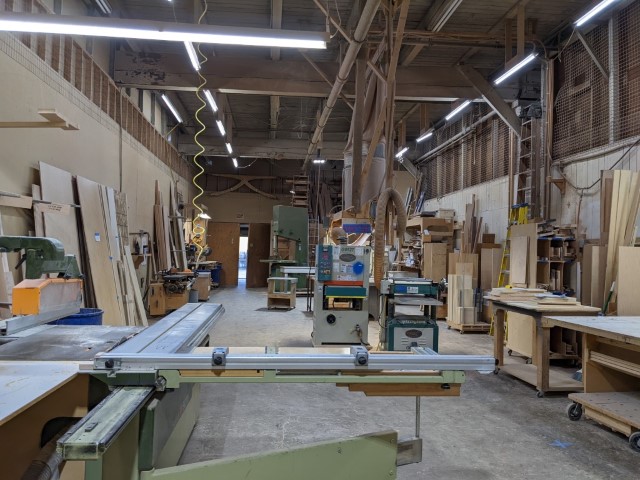 the view down my community woodshop, which has a large thickness planer, jointer, and multiple table saws in view