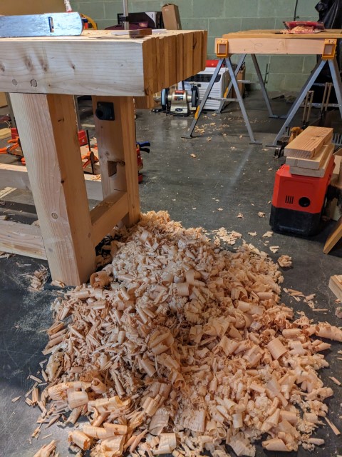 A lot of shavings on the ground from planing the board.